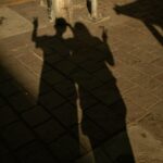 Two people's shadows making peace signs